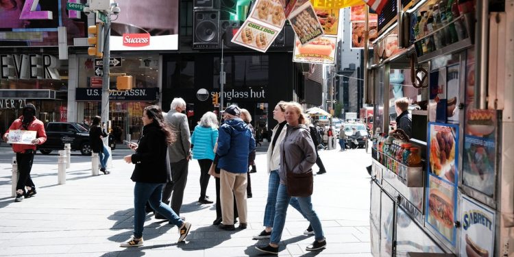 NEW YORK, NEW YORK - APRIL 27: People walk through Times Square on April 27, 2022 in New York City. Unlike other parts of Manhattan, Times Square is quickly returning to its pre-pandemic population with Broadway shows and area hotels at near full capacity on many nights. While office workers in Manhattan have yet to return in large numbers, Times Square is seeing a boom in tourists visiting the historic entertainment core of Manhattan. Dr. Anthony Fauci announced today the America is officially out of the pandemic stage of the Covid-19. (Photo by Spencer Platt/Getty Images)