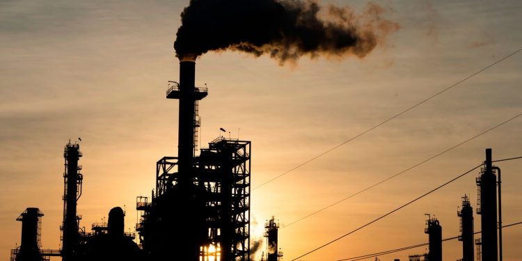 The sun sets behind smoke rising from the LyondellBasell-Houston Refining plant in Houston, Texas, on April 20, 2020. - US oil prices crashed to unprecedented lows on April 20 as futures in New York ended in negative territory for the first time amid a devastating supply glut that has forced traders to pay others to take the crude off their hands. (Photo by Mark Felix / AFP) (Photo by MARK FELIX/AFP /AFP via Getty Images)