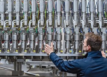 25 April 2022, Bavaria, Neutraubling: A Krones AG employee works on a filling line in production. Photo: Armin Weigel/dpa