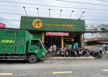 Công nhân dán tem VietGAP vào gói rau mua từ chợ đầu mối đã được sơ chế. Ảnh: Bông Mai/Tuổi Trẻ.